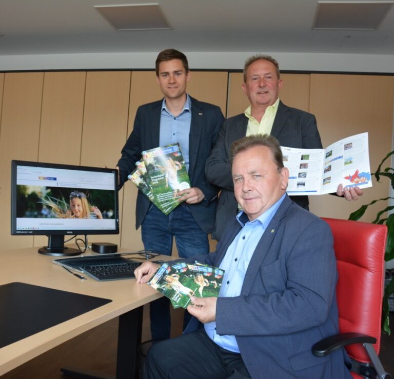 Bürgermeister Franz Mold, Vizebürgermeister Alexander Leutgeb und Johnny Bauer präsentieren den FerienSpiel Folder