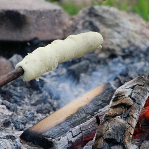 Stockbrot wird über einem Lagerfeuer gegrillt.
